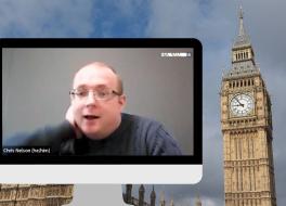 A computer screen showing a man on a video call, with Big Ben in the background