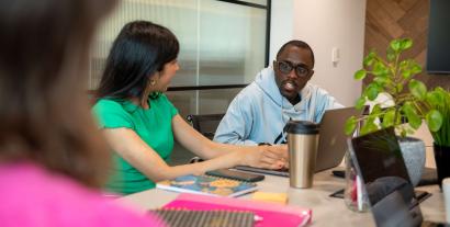 A man talking to a woman at a desk in an office