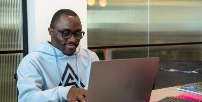A man sitting at a desk working on a laptop