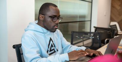 A man sitting at a desk working on a laptop
