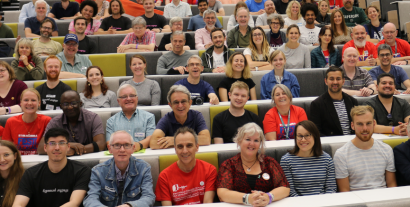 A lecture theatre full of people looking at the camera
