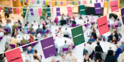 Bunting, with the word 'STAMMA' on it, with a backdrop of a busy dinner hall