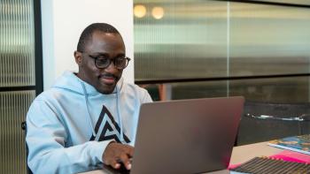 A man sitting at a desk working on a laptop