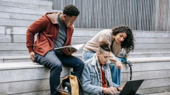 Three college students sitting and studying together