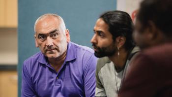Two men sitting in a group therapy setting