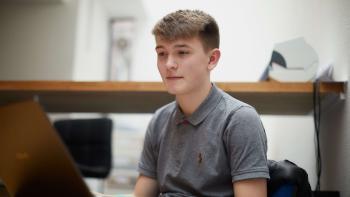 A  young man looking at a laptop computer