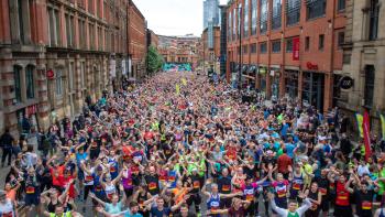 A street full of charity runners all looking at the camera waving their hands