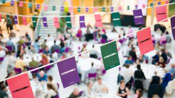 Bunting, with the word 'STAMMA' on it, with a backdrop of a busy dinner hall