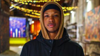 A man in a hood smiling