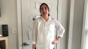 A young woman standing in a room and smiling
