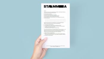 A hand holding a piece of paper with text on it
