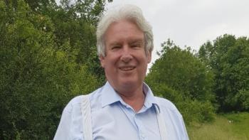 A man in an outdoor setting, smiling