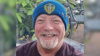 A man wearing a woolie cap, smiling