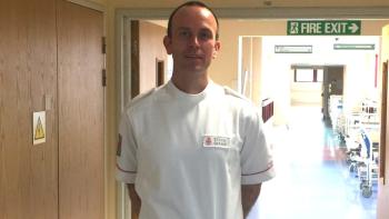 A uniformed man standing in a hospital corridor