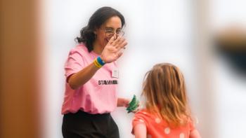 A woman high fiving a young girl, who's back is to the camera