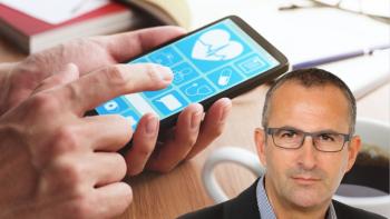 A man's face, in front of a hand using a smartphone