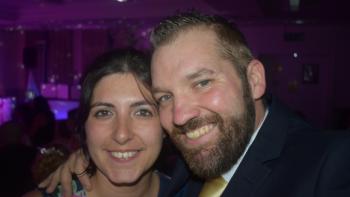 A man and woman with their heads pressed together, smiling