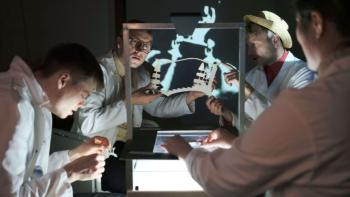 Four men sitting at a table, creating animation frames