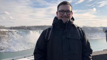 A man standing in front of a waterfall and smiling