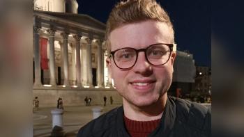 A man smiling for the camera with London's National Gallery behind him