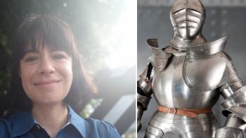 A woman smiling, next to a suit of armour