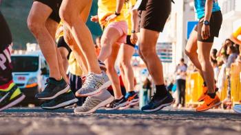 The legs of a group of runners waiting to start a sponsored run