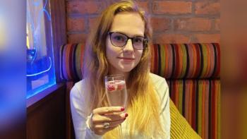 A woman sitting holding a glass of champagne