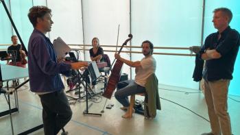 Members of an orchestra rehearsing and chatting