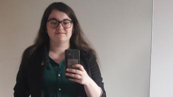 A young woman holding a mobile phone and taking a mirror picture of herself