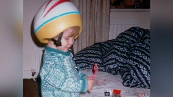 A toddler wearing a crash helmet