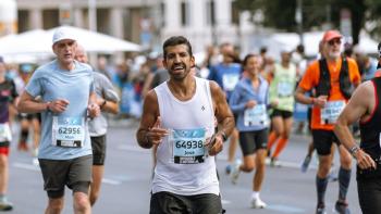 A man running a sponsored charity event, with other runners around him