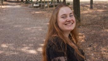 A young woman in a park, smiling