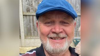 A man wearing a cap and smiling