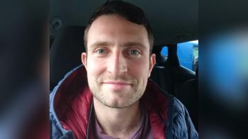 A man sitting in a car and smiling