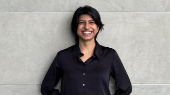 A woman leaning against a wall and smiling