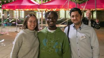 A woman and two men standing side by side and smiling