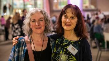 Two women standing next to each other and smiling