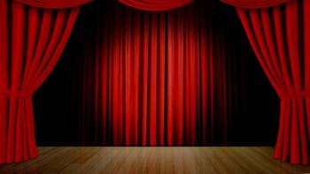 An empty theatre stage, with its curtains open