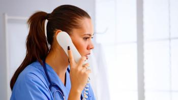 A female nurse speaking into a telephone