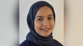 A woman wearing a headscarf, smiling