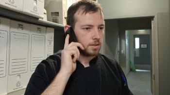 A man speaking into a telephone and looking frustrated