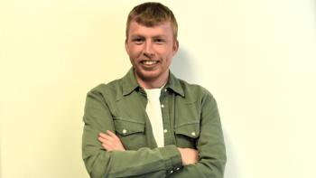 A man with his arms folded, and smiling