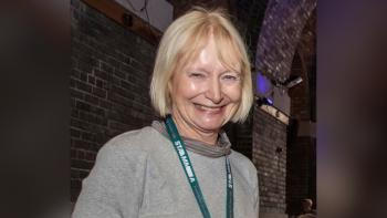 A woman wearing a lanyard and smiling