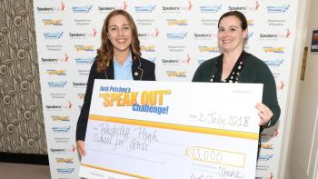 A schoolgirl and a woman holding an out-sized cheque