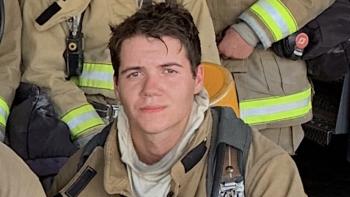A man in a firefighting uniform, smiling
