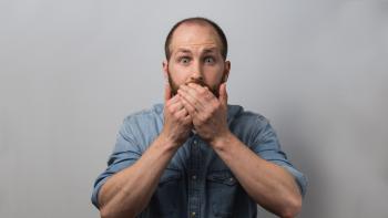 A man covering his mouth with his hands in staged surprise