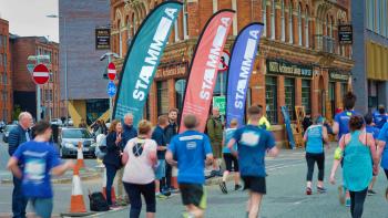 People on a sponsored run, with spectators cheering them on