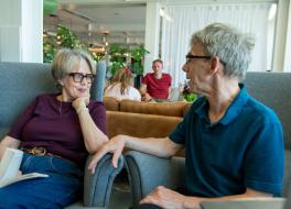 A woman and a man sitting next to each other and chatting