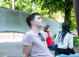 A man sitting in an outside setting an looking into the sky