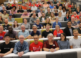 A lecture theatre full of people looking at the camera